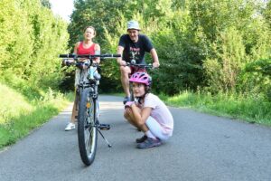 Rodina sa bicykluje po lesnej ceste.